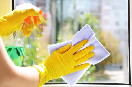housekeeper cleaning a window